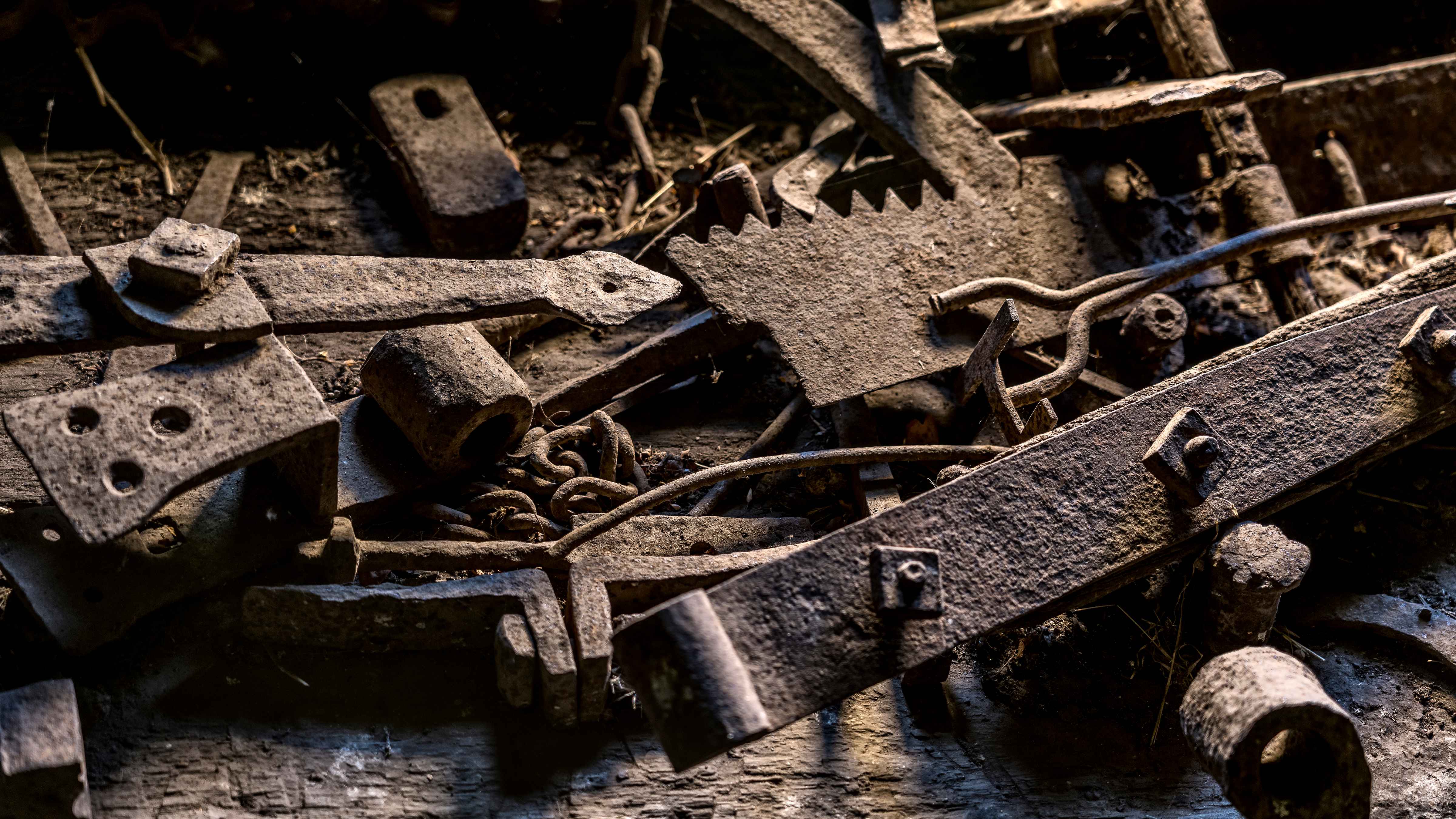 A collection of old metal items that include gate hinges, saw blade, chain and branding iron. Gate hinge is metal branded with W.A. Photo: Rob Burnett.